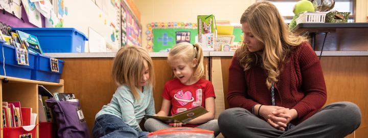 Teacher and young students reading