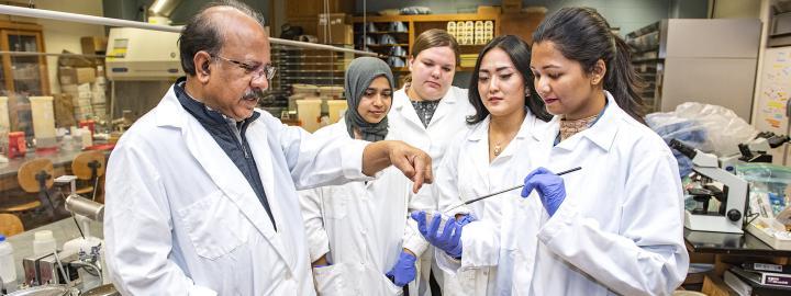 Ahmed Mustafa works with his lab assistants